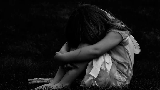 Una niña sobre la hierba Imagen de archivo de una niña sobre la hierba