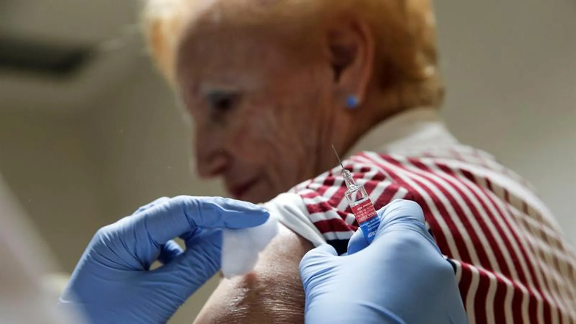 Una mujer recibe una dosis de la vacuna de la gripe