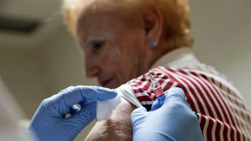 Una mujer recibe una dosis de la vacuna de la gripe