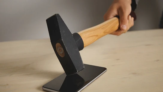 Golpean una pantalla de móvil con un martillo Golpean una pantalla de móvil con un martillo