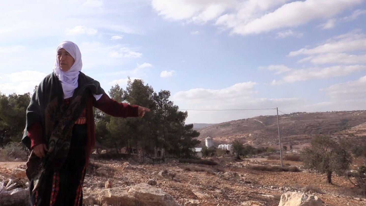 Una anciana palestina se&ntilde;ala las tierras de su propiedad, sobre las que se asienta la colonia de Amon&aacute; 