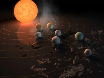 Representación artística que muestra la estrella TRAPPIST-1 y sus planetas marcando su potencial para albergar agua líquida según la temperatura superficial a la que se encuentran Representación artística que muestra la estrella TRAPPIST-1 y sus planetas marcando su potencial para albergar agua líquida según la temperatura superficial a la que se encuentran