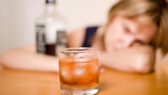Una mujer ante un vaso con alcohol Una mujer ante un vaso con alcohol