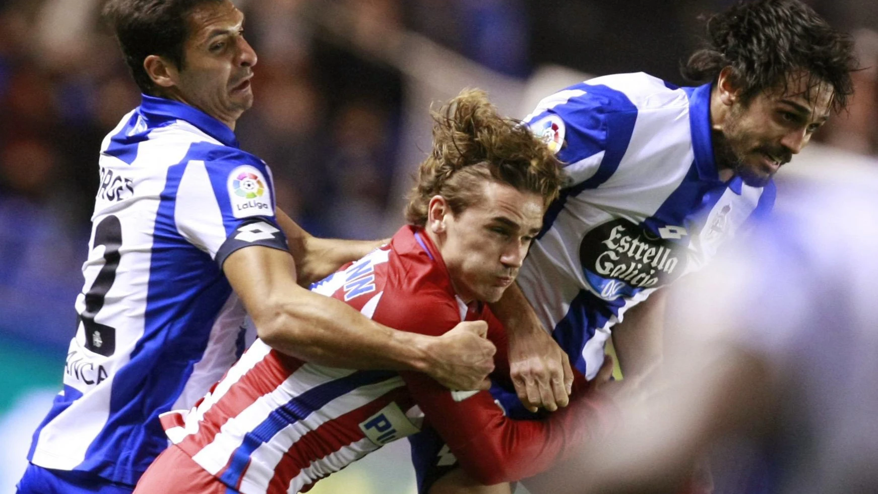 Griezmann lucha por un balón ante los defensores del Deportivo