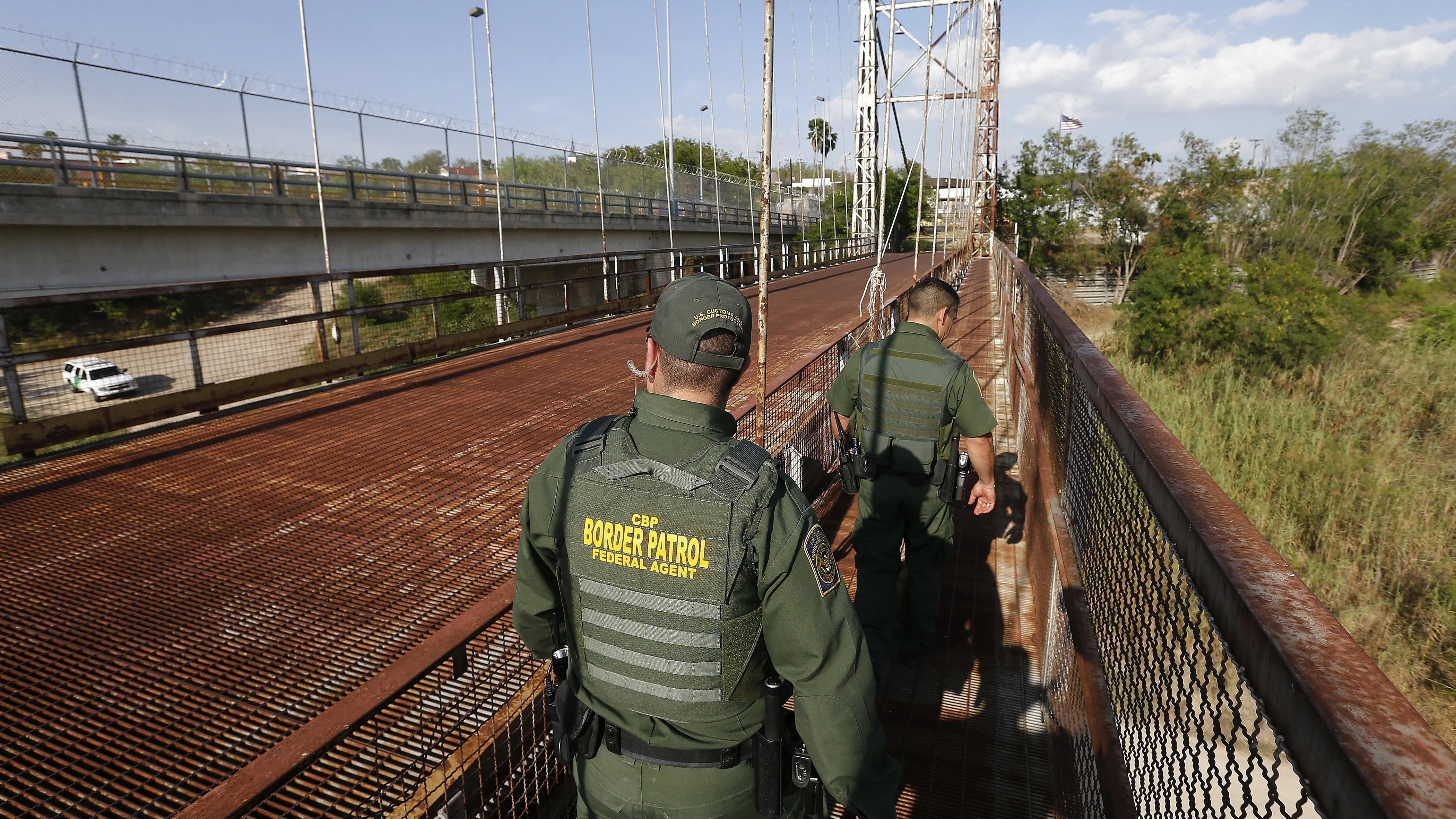 Un par de agentes de la Patrulla de Fronteras de EEUU patrullan por la orilla del Río Grande