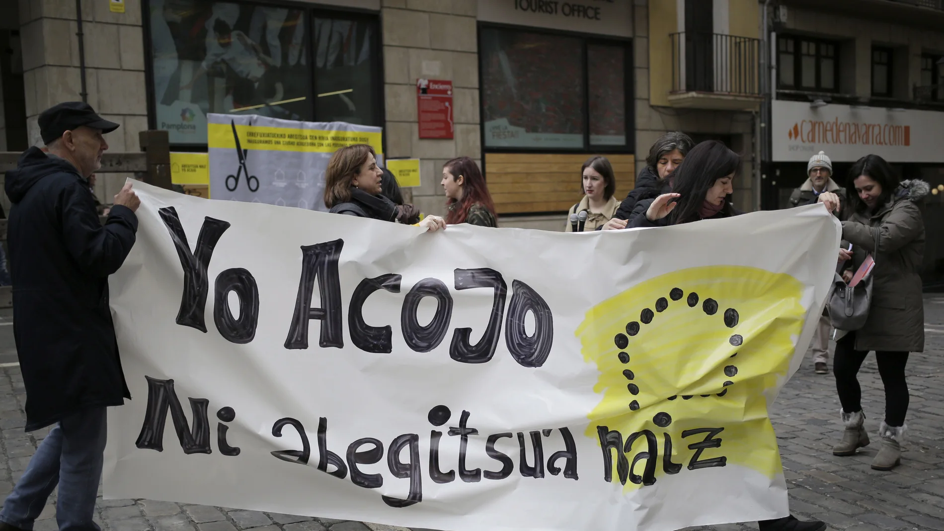Integrantes de Amnistía Internacional durante la celebración hoy en la Plaza del Ayuntamiento de Pamplona de un acto simbólico de "inauguración" de la capital navarra como "Ciudad de acogida" de refugiados