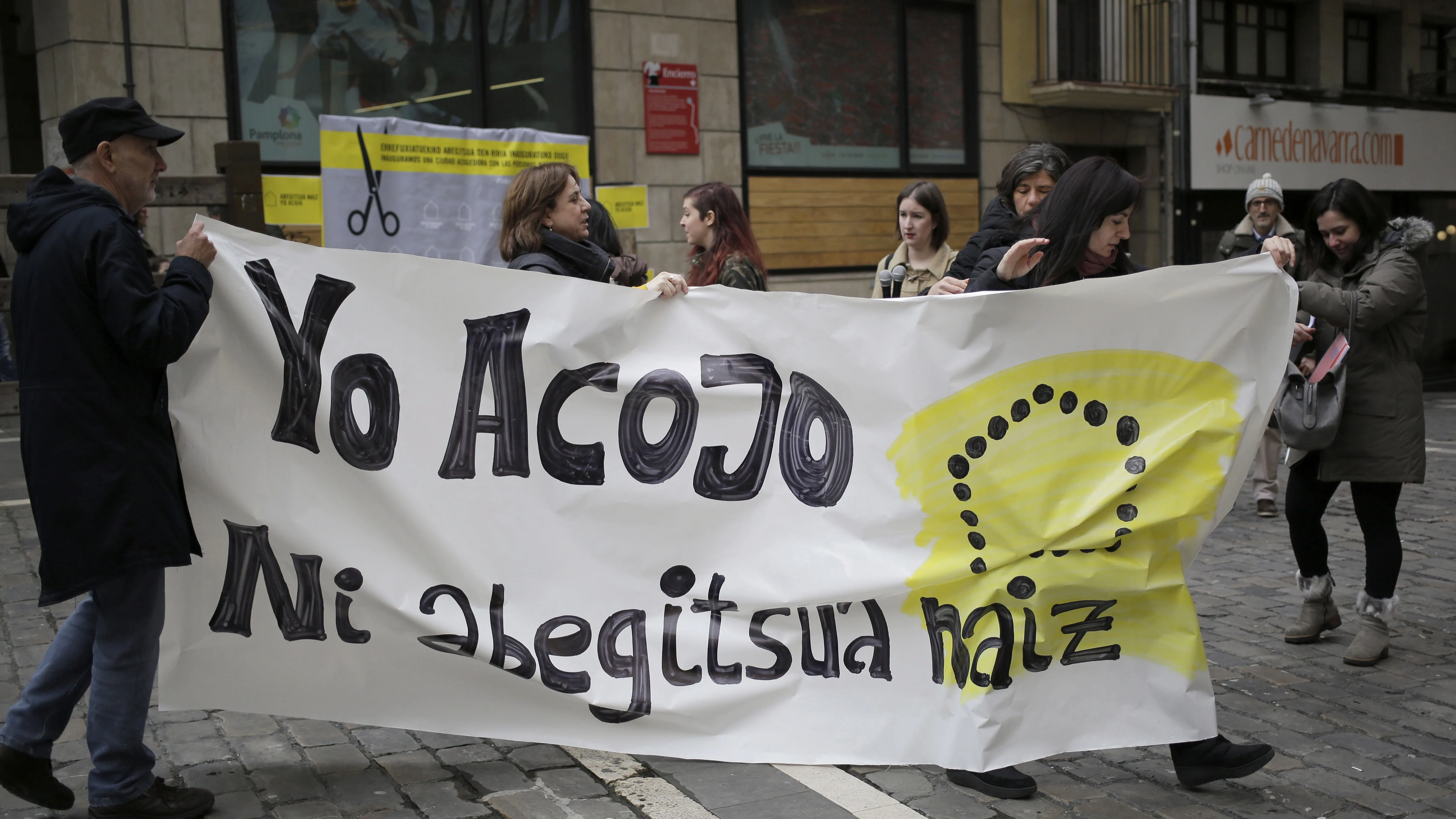 Integrantes de Amnistía Internacional durante la celebración hoy en la Plaza del Ayuntamiento de Pamplona de un acto simbólico de "inauguración" de la capital navarra como "Ciudad de acogida" de refugiados