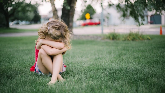 Imagen de archivo de una niña pequeña Una niña pequeña llora sentada en el suelo.