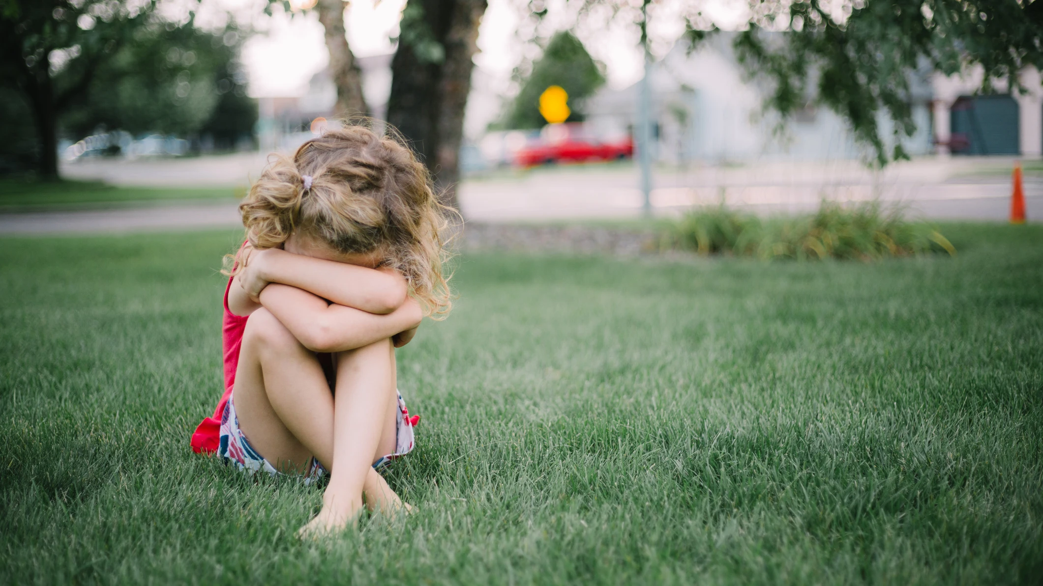 Una niña pequeña llora sentada en el suelo.