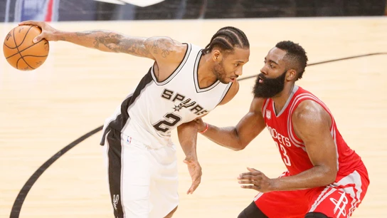 Kawhi Leonard sostiene el balón con una mano ante la defensa de James Harden Kawhi Leonard sostiene el balón con una mano ante la defensa de James Harden