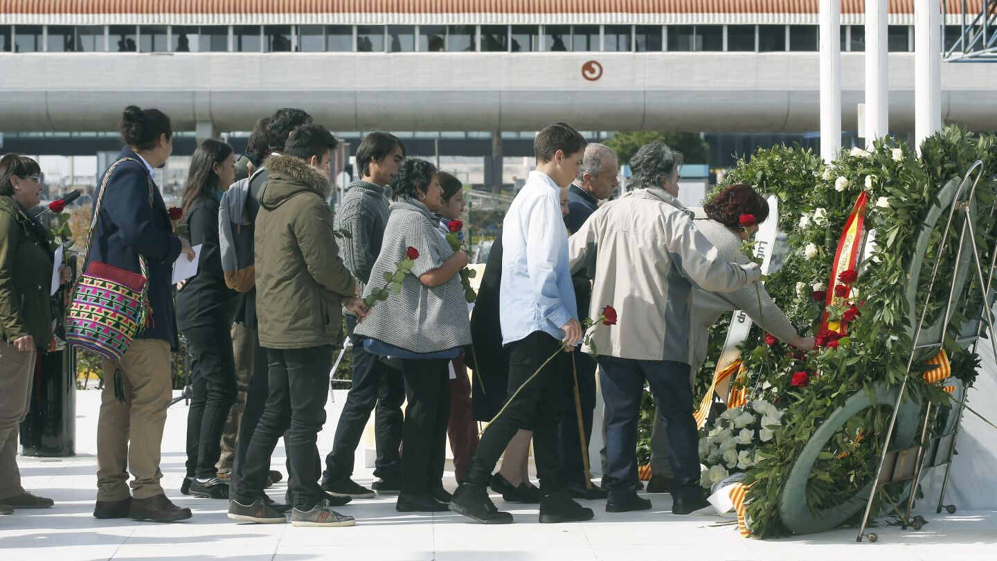 Varios familiares dejan rosas rojas en el monumento de recuerdo durante el acto de homenaje a las v&iacute;ctimas del accidente del vuelo Germanwings 9525