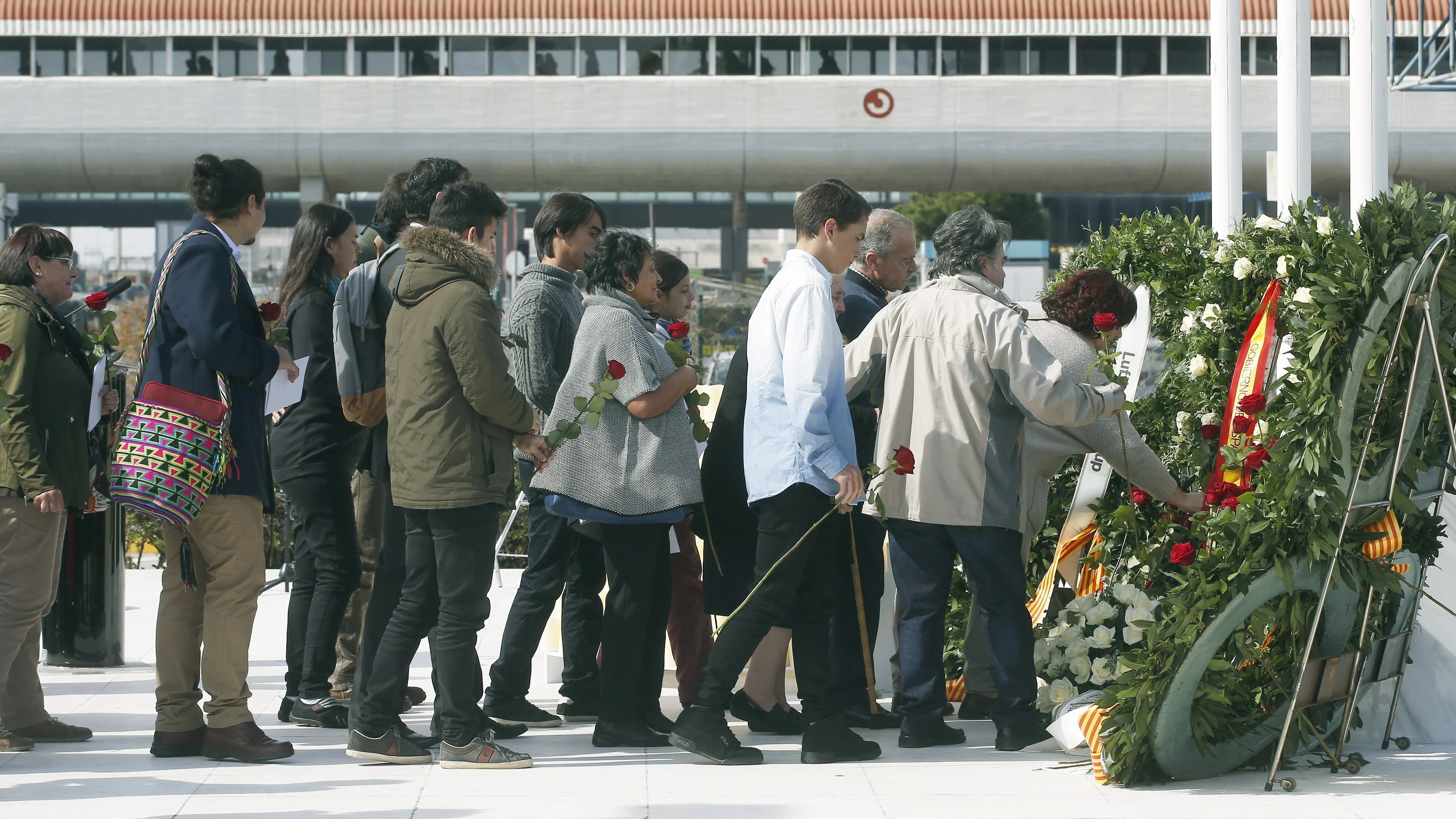 Varios familiares dejan rosas rojas en el monumento de recuerdo durante el acto de homenaje a las víctimas del accidente del vuelo Germanwings 9525