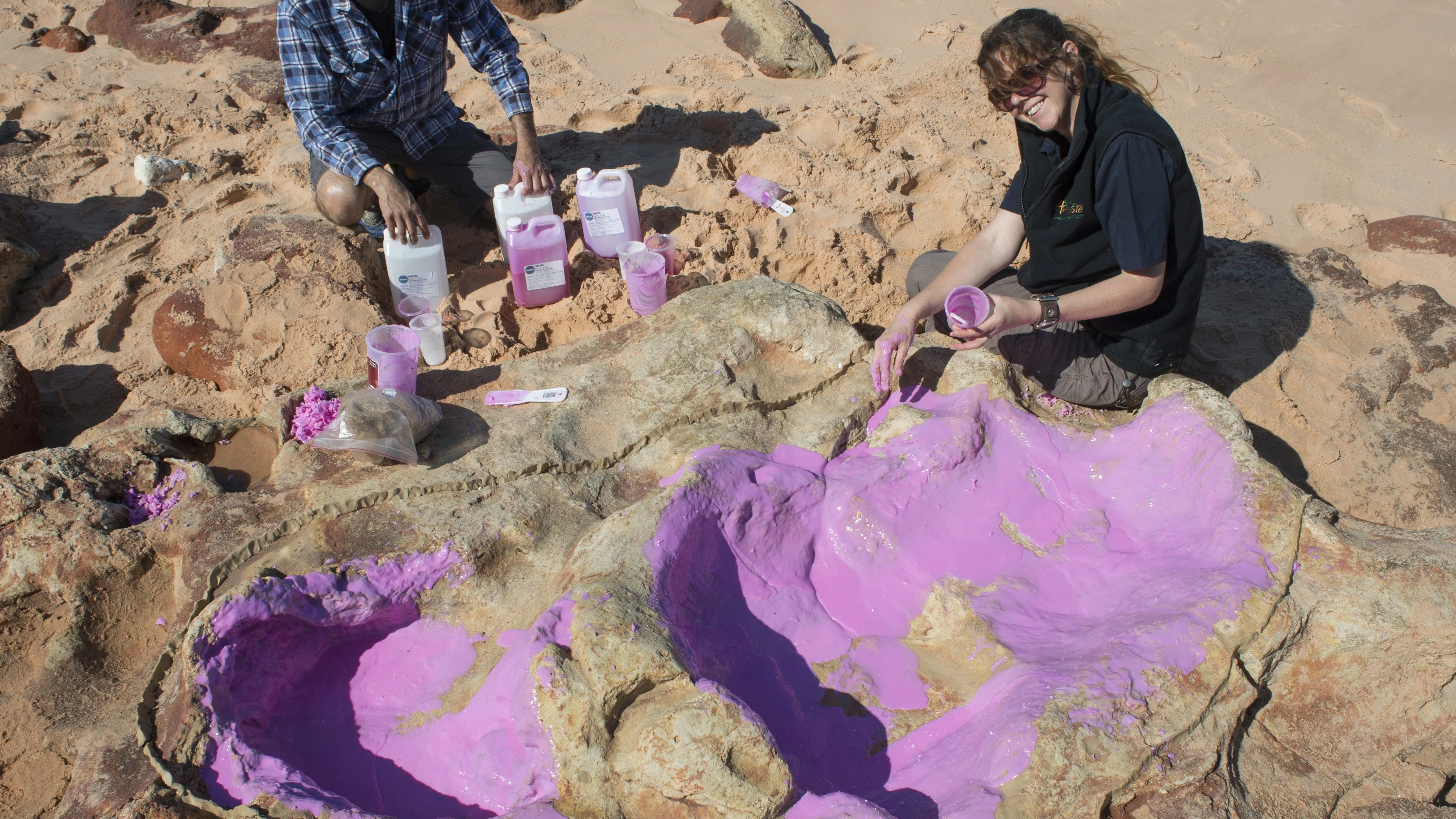 Fotografía facilitada por la Universidad de Queensland de científicos creando un molde de silicona en la huella de un dinosaurio. 