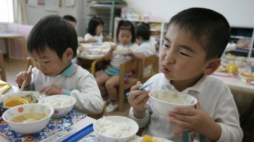 Dos niños disfrutan de su almuerzo en el comedor escolar