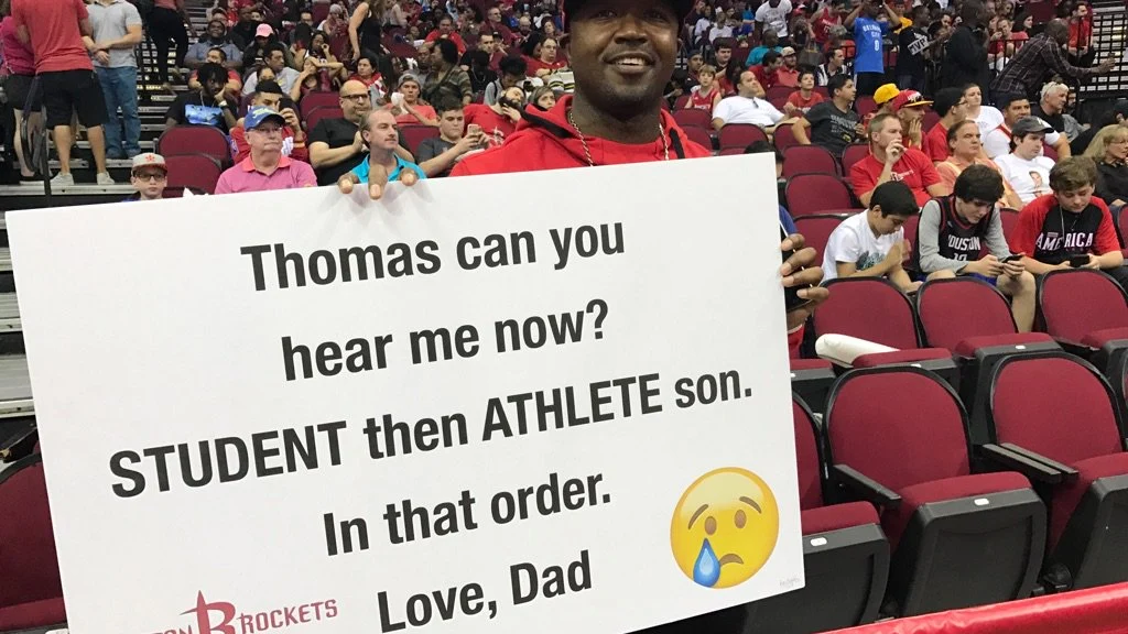 El padre, con una de sus pancartas en la cancha de los Rockets
