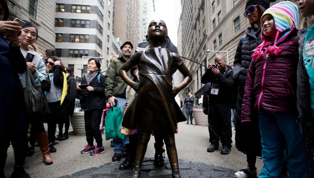 Varias personas observan la estatua en Wall Street de la 'Niña sin miedo'