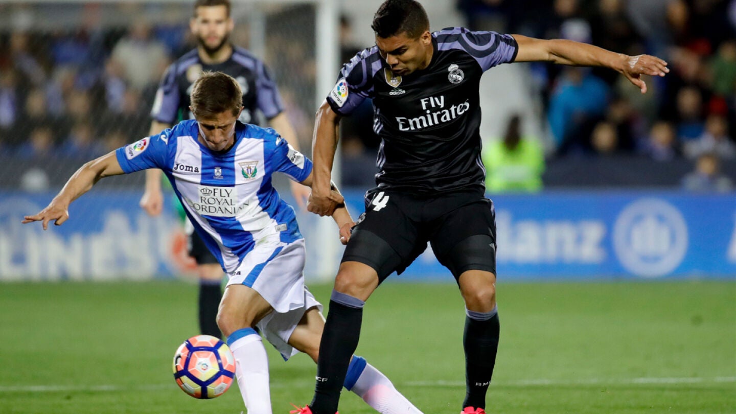 El centrocampista brasile&ntilde;o del Real Madrid, Carlos Henrique Casemiro, disputa un bal&oacute;n con el jugador argentino del Legan&eacute;s, Alexander Szymanowski