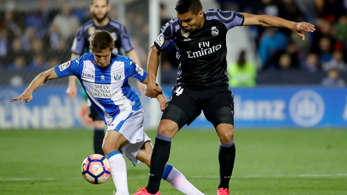 El centrocampista brasileño del Real Madrid, Carlos Henrique Casemiro, disputa un balón con el jugador argentino del Leganés, Alexander Szymanowski