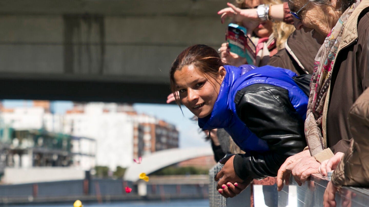 Varias personas tiran p&eacute;talos al agua durante la Ceremonia del R&iacute;o, en la que se simboliza la salida de los antepasados de los gitanos y gitanas de la regi&oacute;n del Punjab en la India 