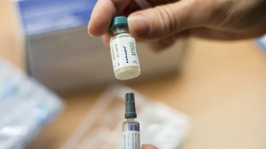 Una enfermera sostiene una vacuna Una enfermera sostiene una vacuna