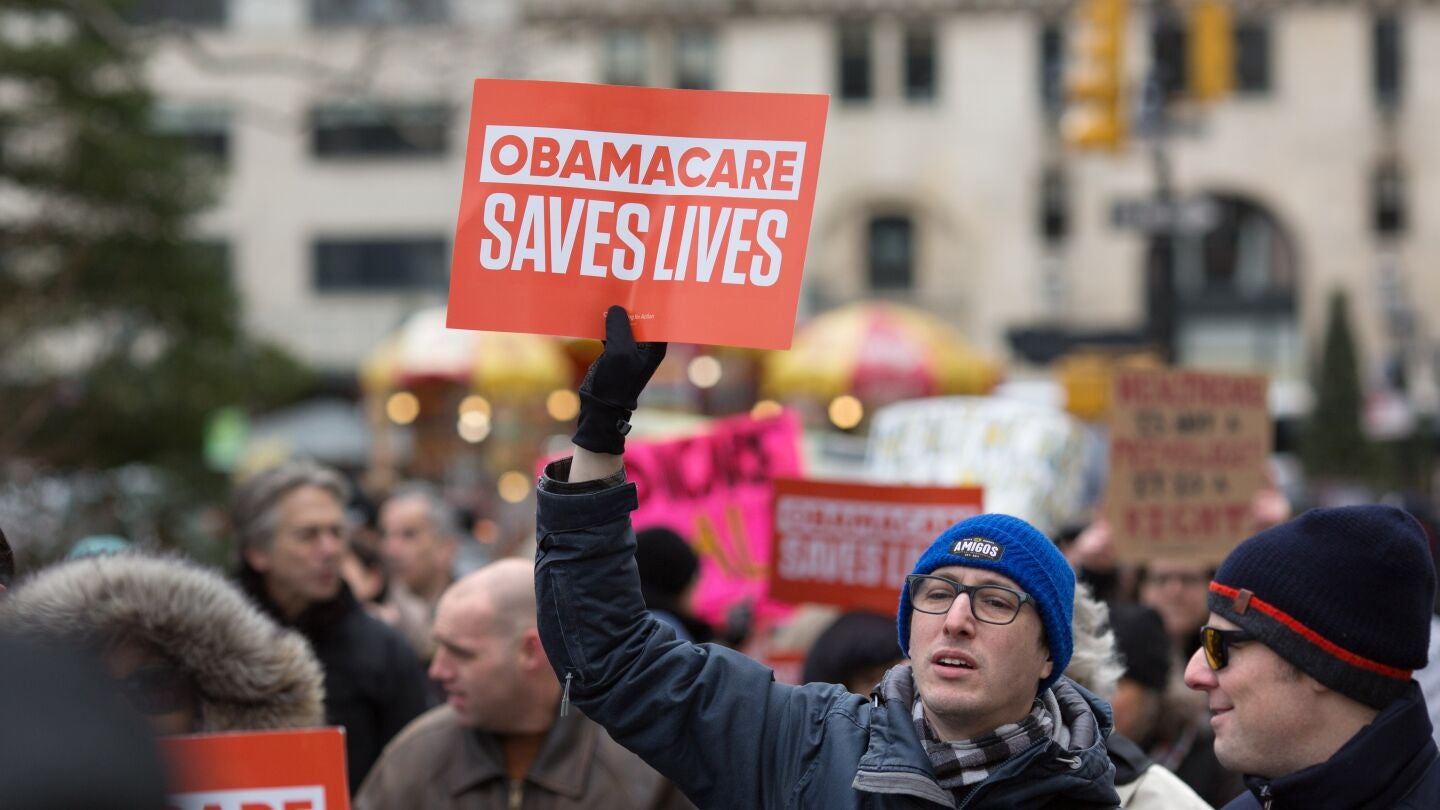 Un manifestante sostiene un cartel con el mensaje 'Obamacare salva vidas'