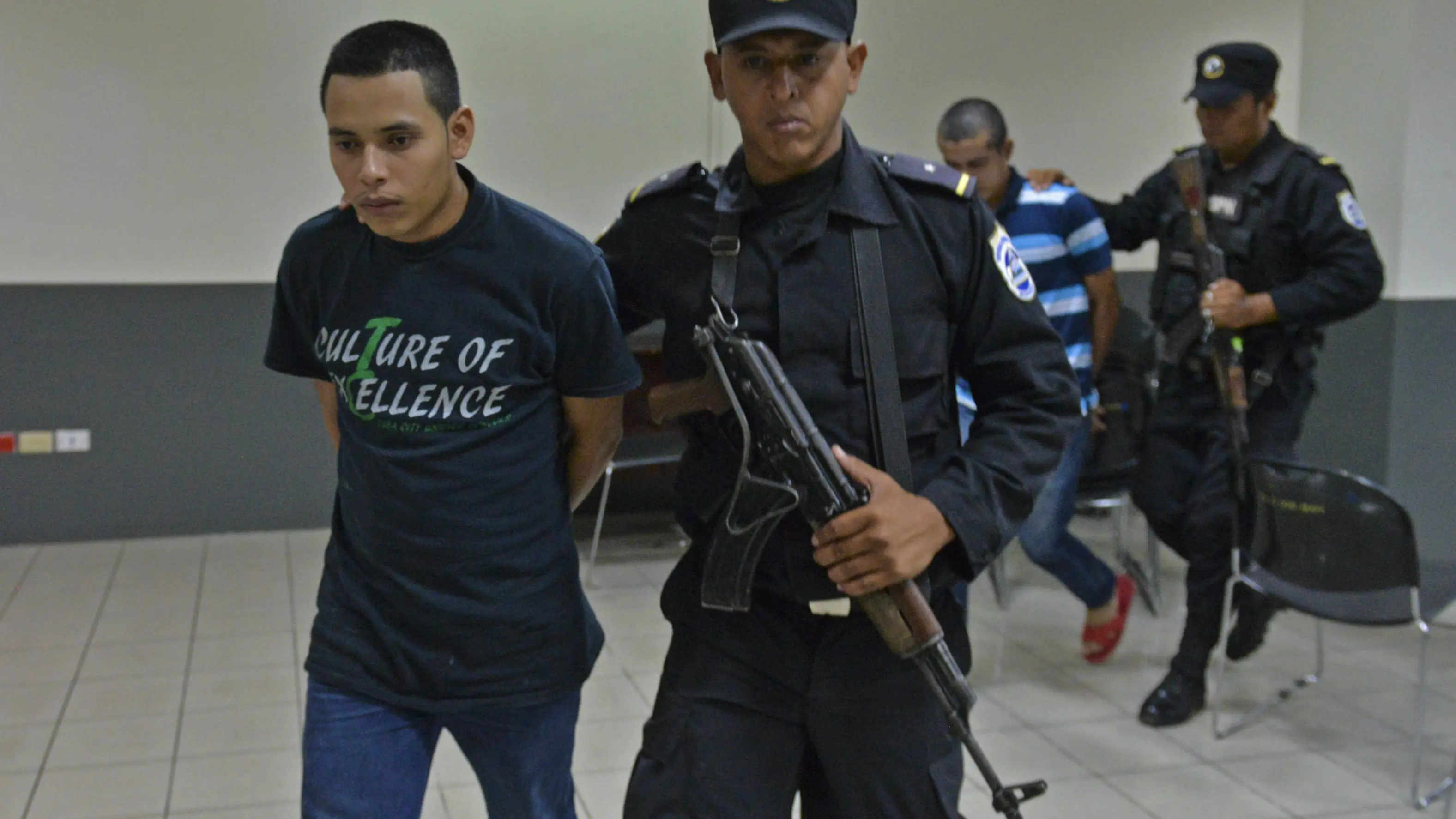 El pastor evangélico Juan Gregorio Rocha Romero (i), acusado de asesinato y secuestro simple, es escoltado por un agente de seguridad de la Policía Nacional en el juzgado de Managua.