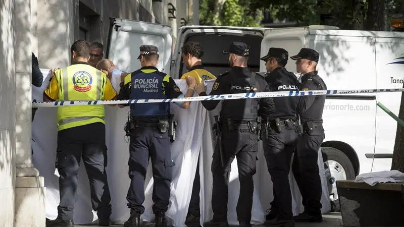 Agentes de la policía y los servicios médicos sacan los cuerpos del edificio