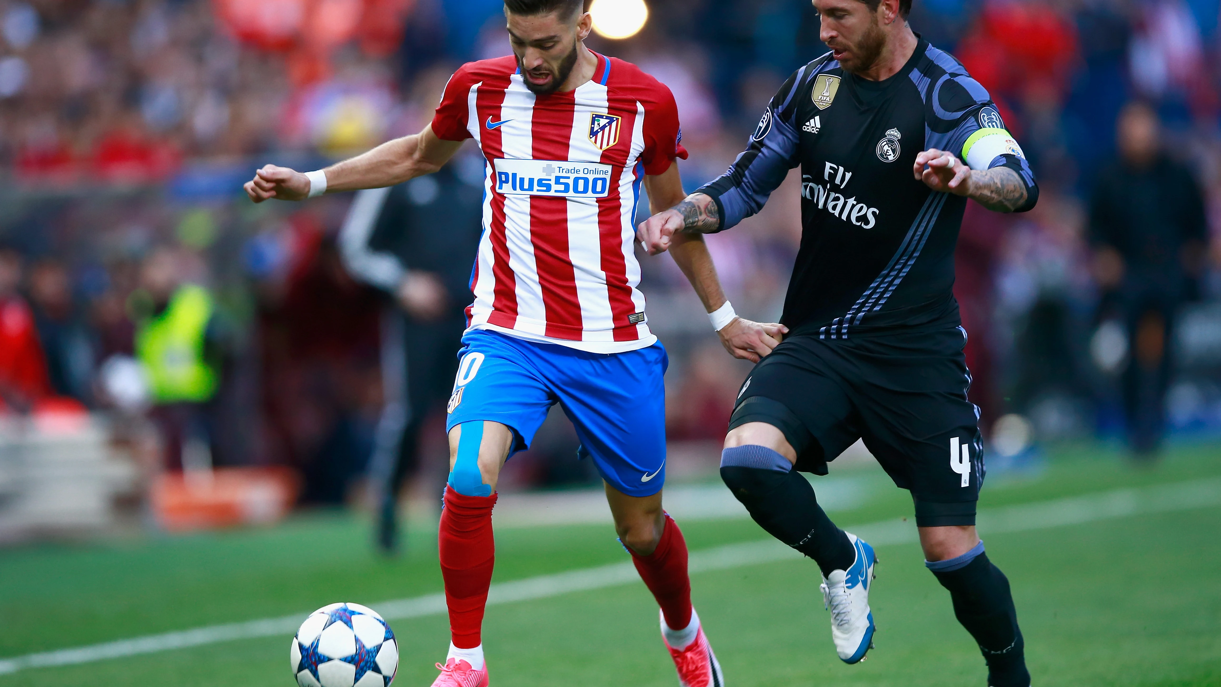 Yannick Carrasco y Sergio Ramos durante el Atlético - Real Madrid