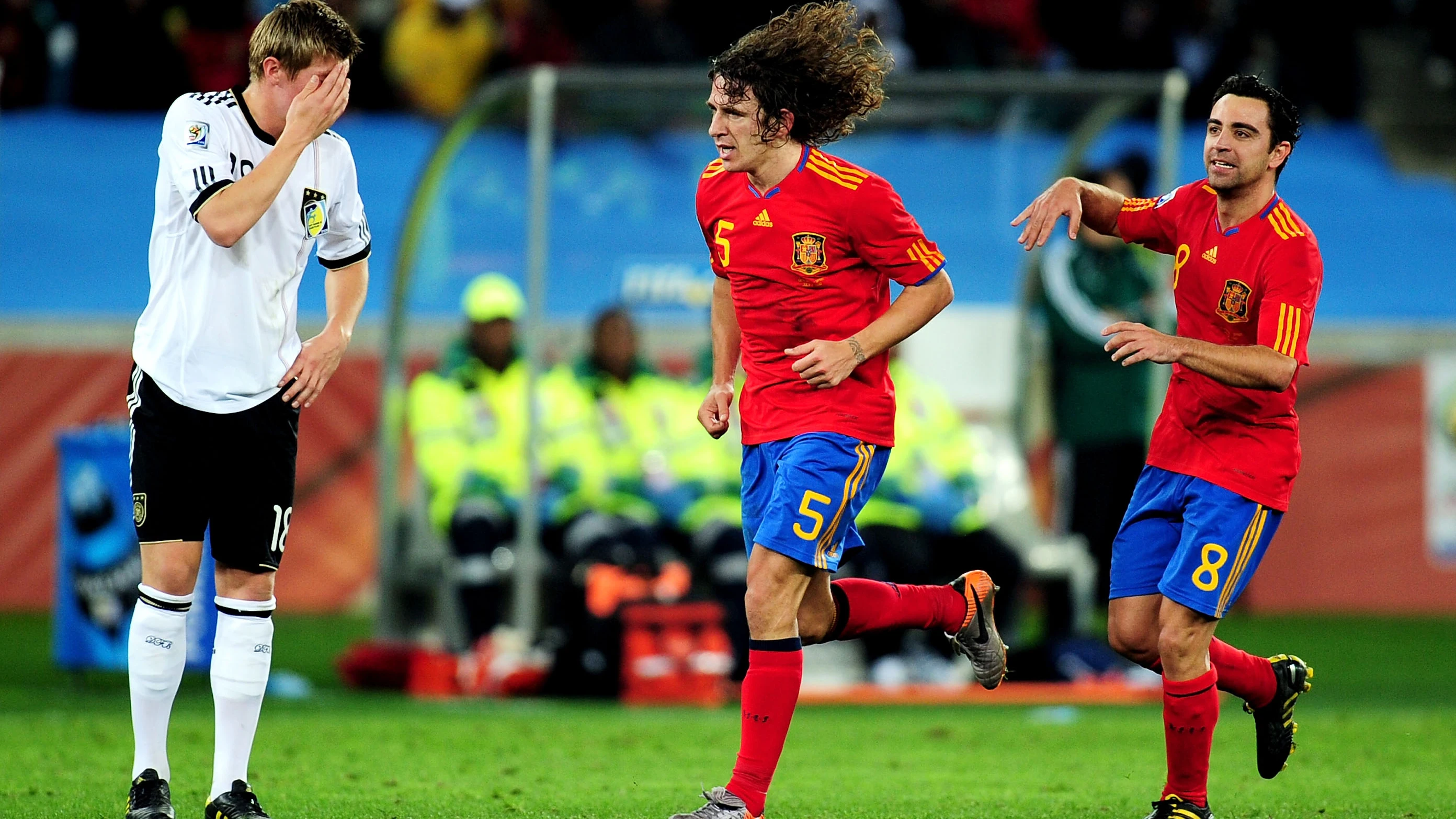 Toni Kroos se lleva la mano a la cabeza ante Puyol y Xavi