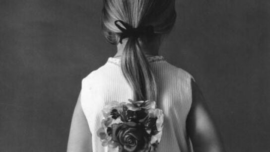 Una ni&ntilde;a de espalda con una flor