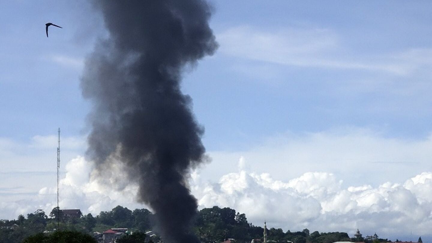Una cortina de humo se eleva despu&eacute;s de un bombardeo durante los combates