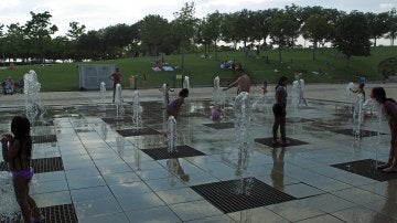 Niños jugando con agua en una fuente