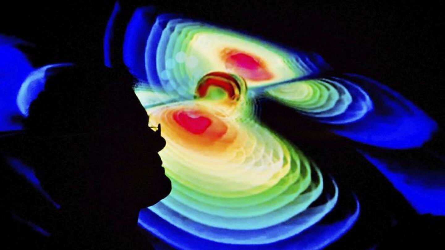 Un cient&iacute;fico observa una representaci&oacute;n de las ondas gravitacionales 