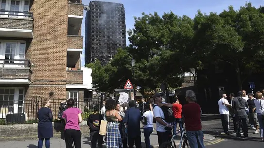 Varias personas observan la Torre Grenfell tras apagarse el incendio Varias personas observan la Torre Grenfell tras apagarse el incendio