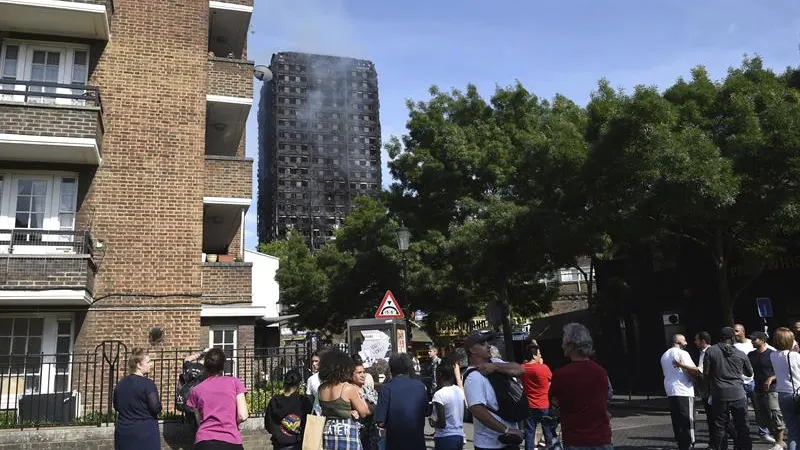 Varias personas observan la Torre Grenfell tras apagarse el incendio 