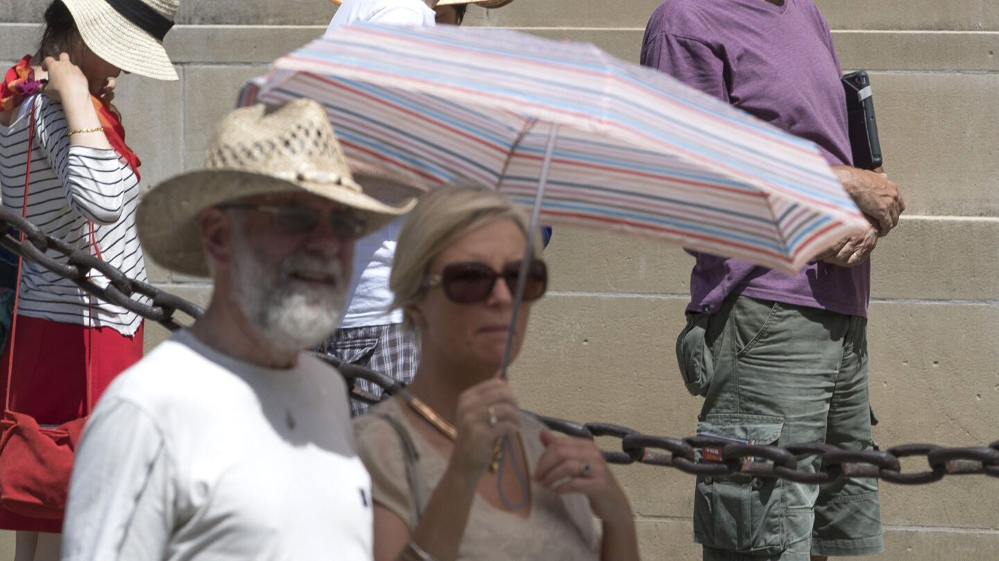 Turistas se protegen del calor frente a la Catedral de Sevilla