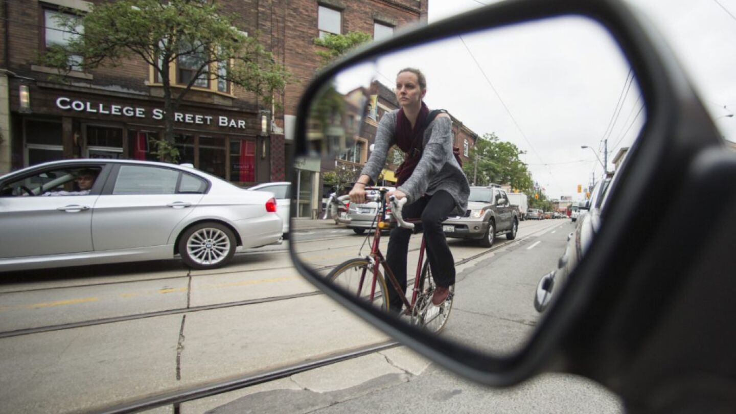 Una persona en una bici vista a trav&eacute;s de un retrovisor
