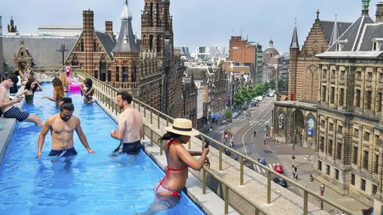 Un grupo de amigos disfrutan de una piscina en la azotea de un hotel en la ciudad de Ámsterdam Un grupo de amigos disfrutan de una piscina en la azotea de un hotel en la ciudad de Ámsterdam