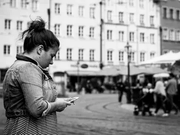 Una usuaria con su teléfono móvil Una usuaria con su teléfono móvil