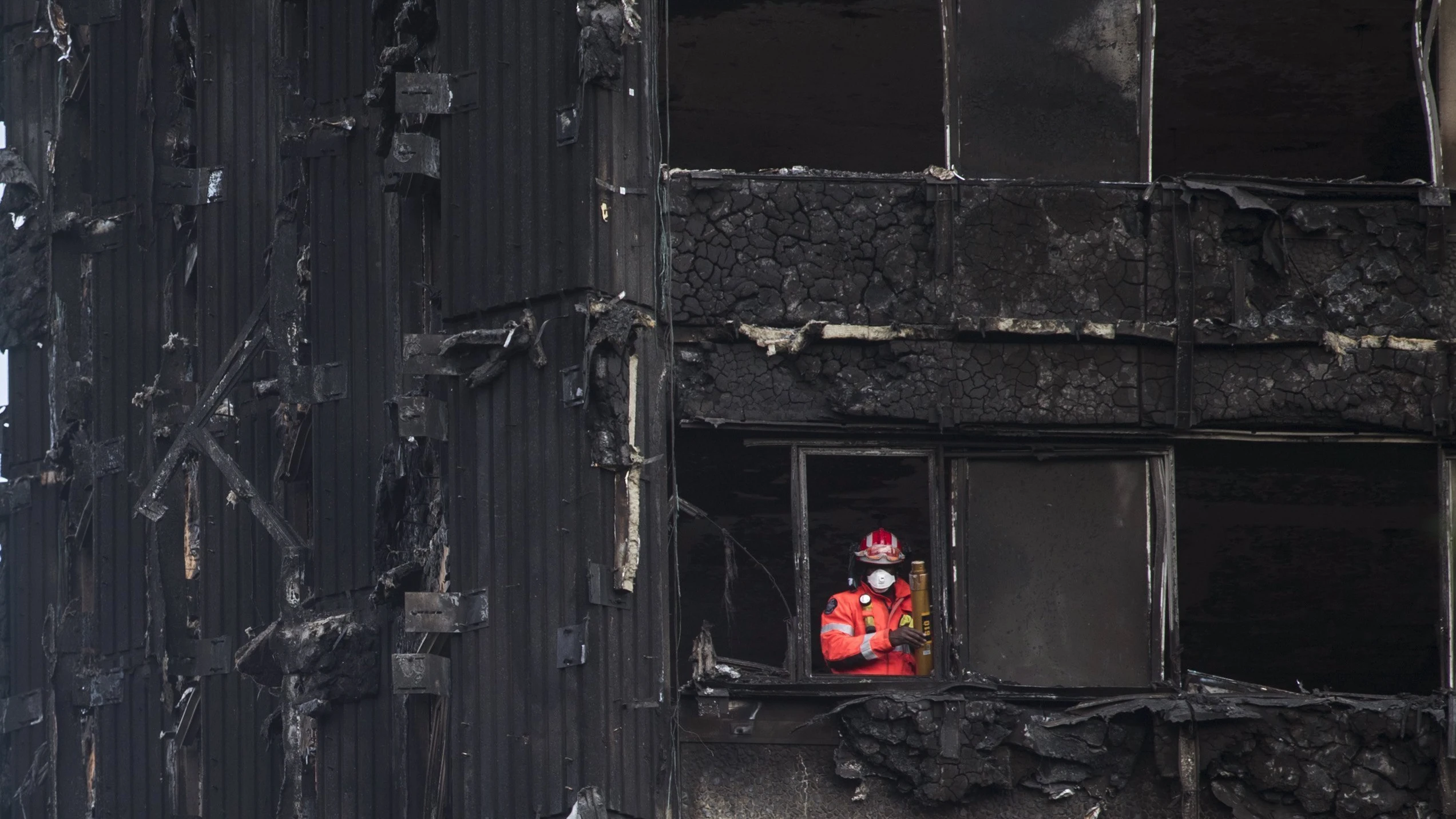 Un bombero inspecciona los restos de la Torre Grenfell en Londres