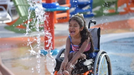 Una niña con discapacidad disfrutando del nuevo parque acuatico Una niña con discapacidad disfrutando del nuevo parque acuatico