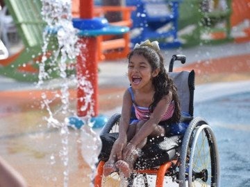 Una niña con discapacidad disfrutando del nuevo parque acuatico Una niña con discapacidad disfrutando del nuevo parque acuatico