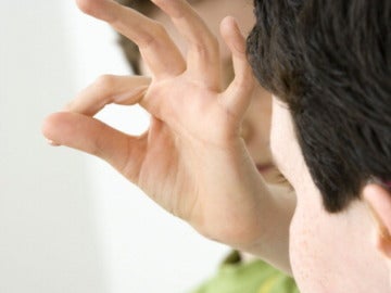 Dos personas mantienen una conversación mediante el lenguaje de signos