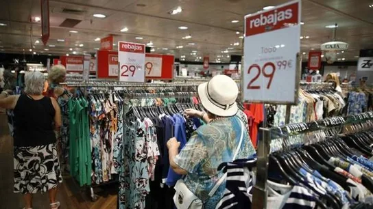 Imagen de archivo de varias personas mirando la ropa de rebajas en verano Imagen de archivo de varias personas mirando la ropa de rebajas en verano