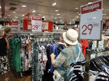 Imagen de archivo de varias personas mirando la ropa de rebajas en verano Imagen de archivo de varias personas mirando la ropa de rebajas en verano