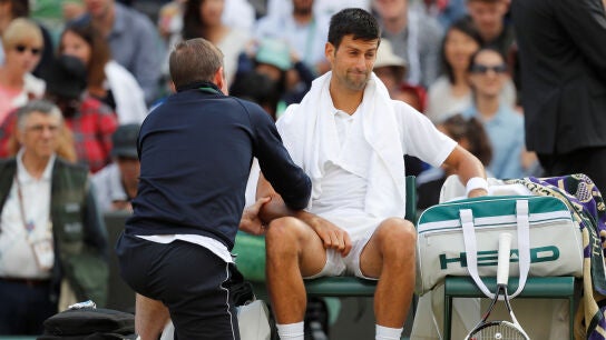 Novak Djokovic, atendido por un fisioterapeuta en Wimbledon