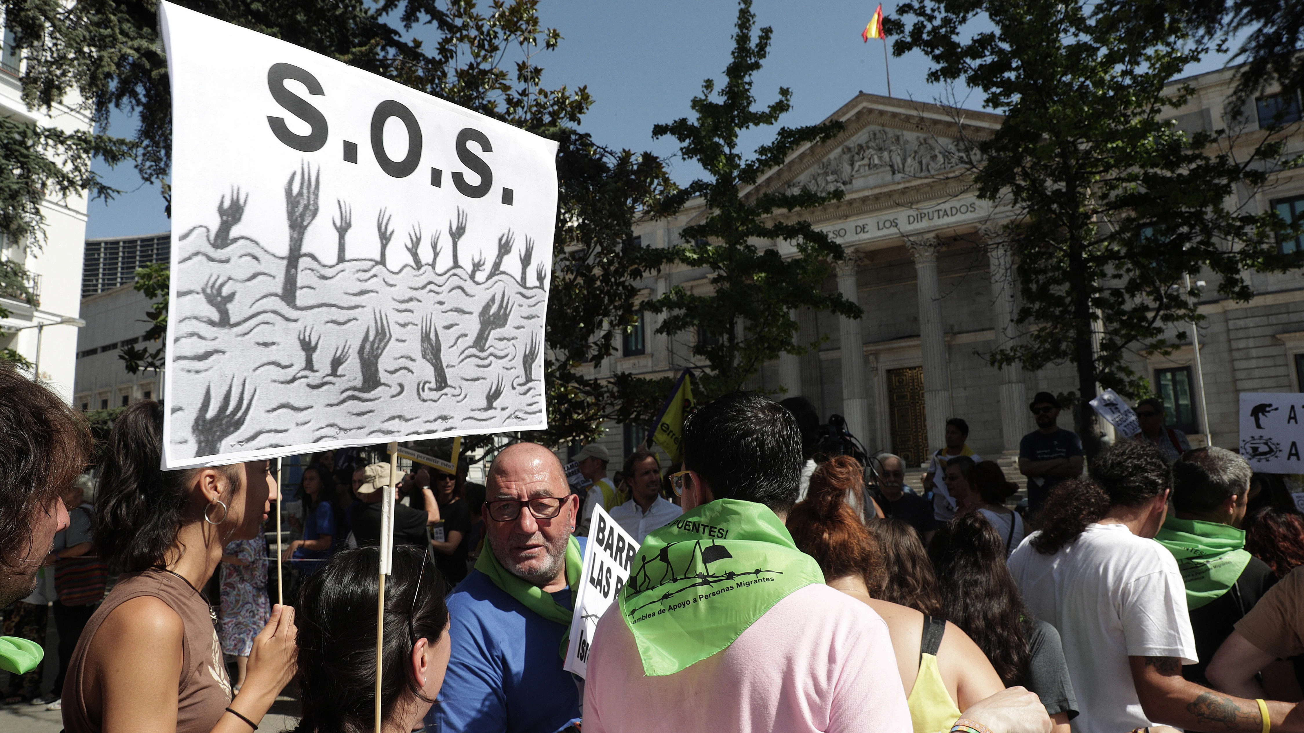 Miembros de unos 100 colectivos por los derechos de las personas migrantes durante la concentración que han protagonizado hoy ante el Congreso para despedir a la Caravana Abriendo Fronteras