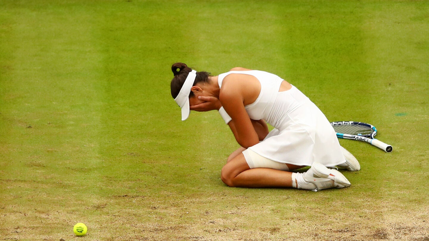 Garbi&ntilde;e Muguruza llora sobre la pista central de Wimbledon tras ganar la final