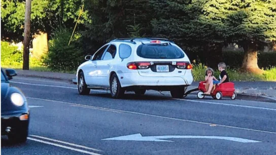 La mujer arrastrando a los niños con su coche La mujer arrastrando a los niños con su coche