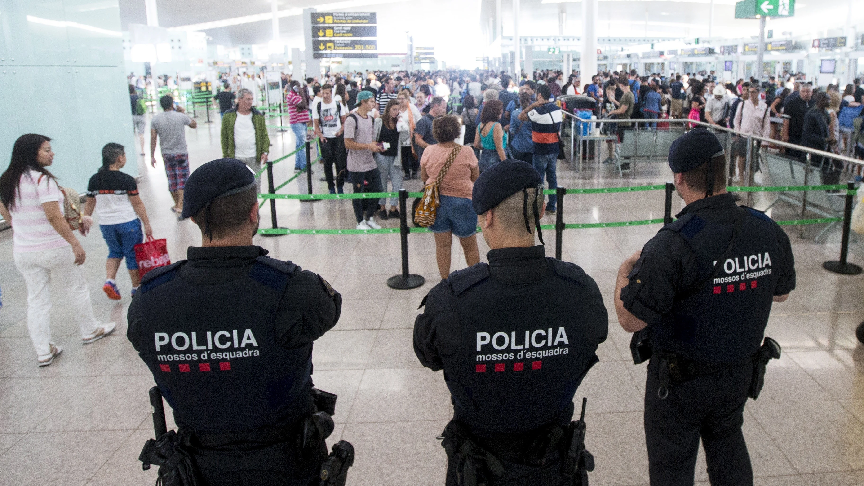 Agentes de los Mossos d'Esquadra controlan de los accesos a las puertas de embarque en el Aeropuerto de El Prat